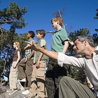 Teacher directing students in forest