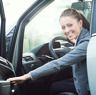 Young woman opening car door