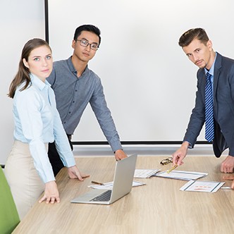 Serious young businesspeople standing in boardroom