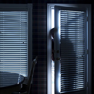 Burglar Breaking In To Home At Night Through Back Door