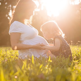 Child kissing belly og pregnant mother