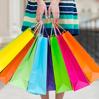 Woman holding colourful shopping bags at the mall.