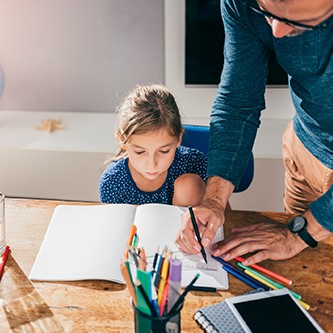 Father helping daughter to finish homework