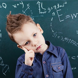 Little boy near blackboard with formulas