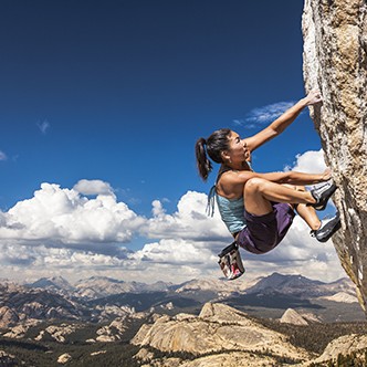 Rock climber clinging to a cliff.