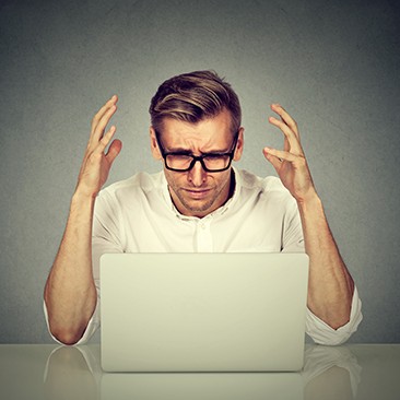 Stressed man working on computer.