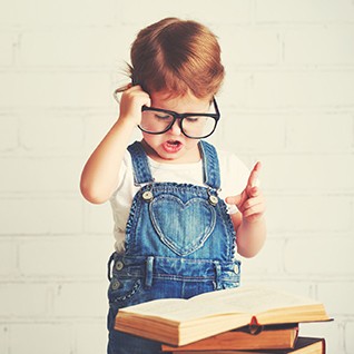 child little girl with glasses reading a books