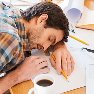 Man feeling exhausted and sleeping on working desk