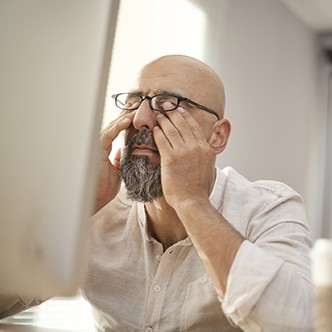 Senior businessman rubbing his tired eyes