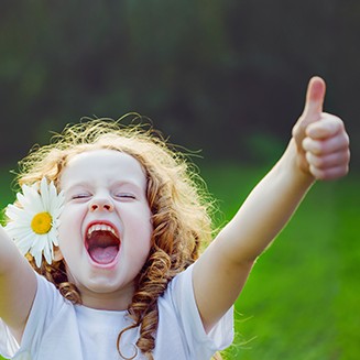 Laughing girl showing thumbs up.