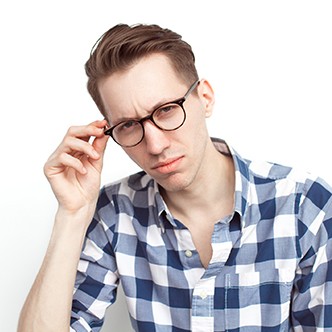 Thoughtful man touching glasses