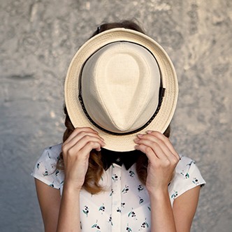 Young girl with hat. Hides her face.Depression.